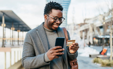 man holding a smartphone and credit card